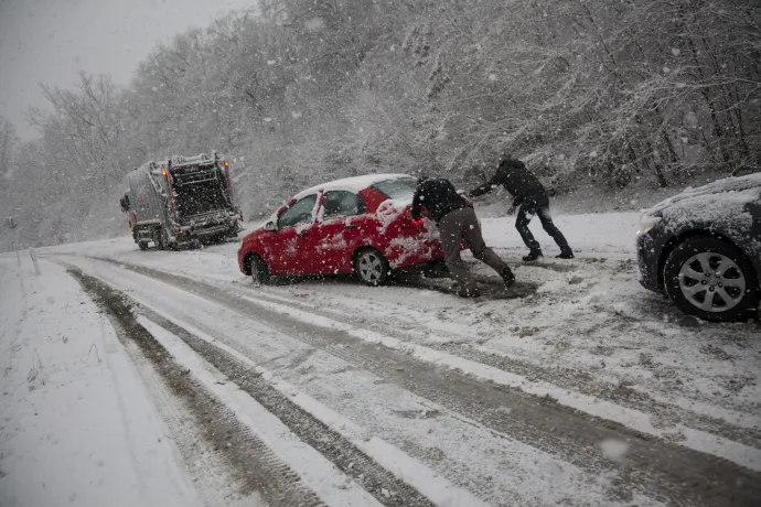 Elakadt autót tolnak a sűrű hóesésben a 61-es úton a bagolai emelkedőnél, Nagykanizsánál – Fotó: Varga György / MTI