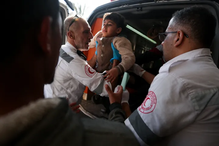 A Palesztina Vörös Félhold Társaság a humanitárius szervezet tagjai sérülteket szállítanak a Nasszer kórházba a Hán Júniszt ért izraeli légicsapásokat követően 2023. december 4-én – Fotó: Ibraheem Abu Mustafa / Reuters