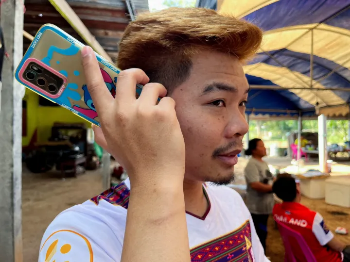 Anucha Angkaew telefonál lakóhelyén a thaiföldi Don Pila faluban december 6-án – Fotó: Devjyot Ghoshal / Reuters