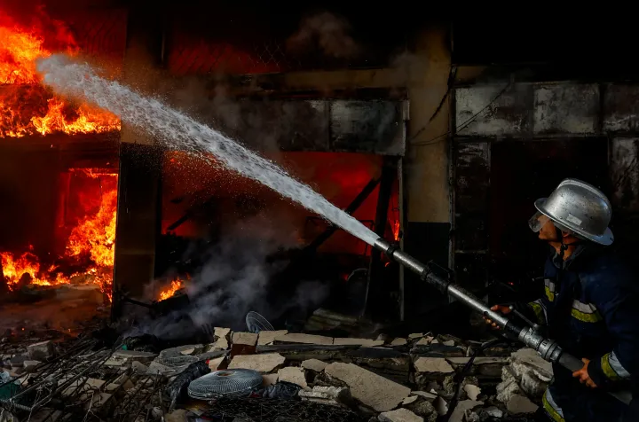 Palesztin tűzoltó oltja a tüzet egy izraeli támadás után Hán Júniszban – Fotó: Ibraheem Abu Mustafa / Reuters