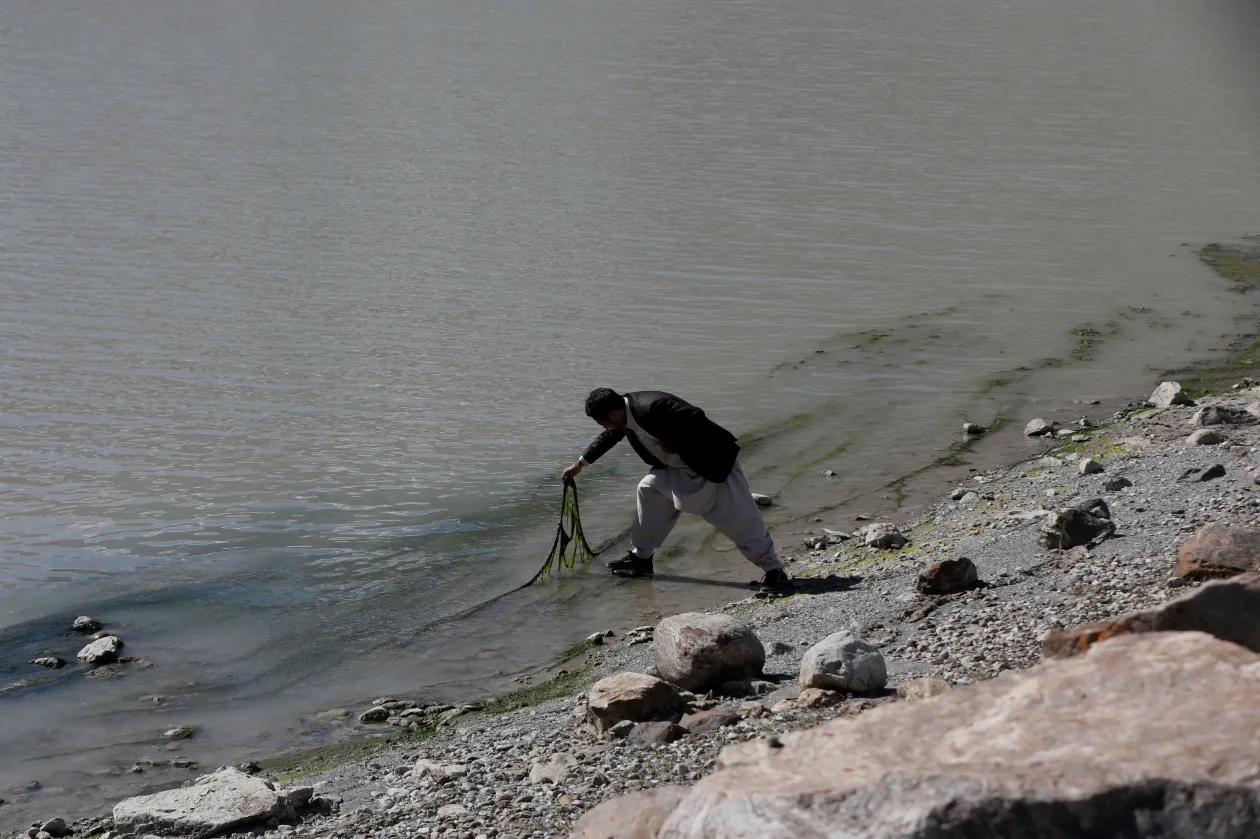 A Gamoo Bhr gleccsertó a Darkut gleccser előtt Darkut faluban, a pakisztáni Gilgit-Baltisztán régióban. A 35 éves Muhammad Yasin, a környezettudományok kutatója az algásodást vizsgálja a tónál, hogy nyomon követhessék a gleccser olvadásának ütemét – Fotó: Akhtar Soomro / Reuters