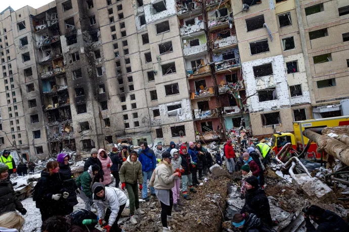 Lakók távolítják el a törmeléket egy lakóház előtt Kijevben, miután megrongálódott egy orosz rakétatámadásban 2024. január 2-án – Fotó: Kirill Chubotin / Ukrinform / NurPhoto / Getty Images