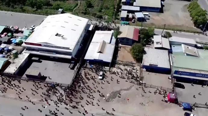 Egy raktárépület Port Moresbyben, körülötte a zavargó tömeggel – Fotó: Mackenzie Waide / Reuters