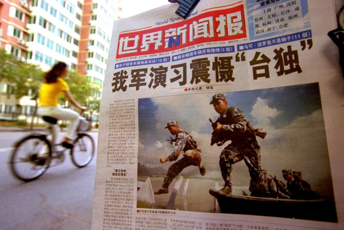 Egy kínai újság 2002-ben, amelynek címlapján a kínai hadsereg katonáit ábrázoló fotó mellett a „A kínai hadgyakorlat megrémíti a függetlenségpártiakat” főcím 2002. augusztus 7-én Pekingben. Peking ekkor számos újságcímben figyelmeztette Tajvant a függetlenségről szóló tajvani népszavazás támogatásának katonai következményeire – Fotó: Kevin Lee / Getty Images