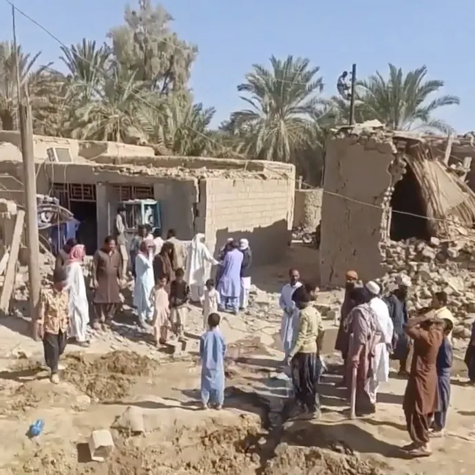 A pakisztáni légicsapás utáni maradványok körül gyülekező beludzs lakosok az iráni Szaravánban – Fotó: Reuters