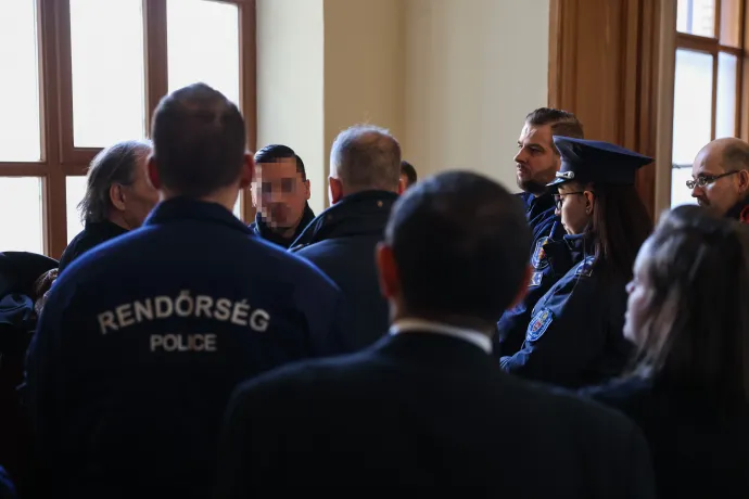 Portik Tamás fia rendőrök gyűrűjében a Fővárosi Törvényszék folyosóján a tárgyalás előtt – Fotó: Melegh Noémi Napsugár / Telex