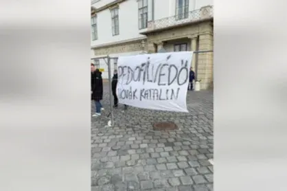 „Pedofilvédő Novák Katalin” feliratot lógatott a Sándor-palotához cipelt kordonokra a Momentum