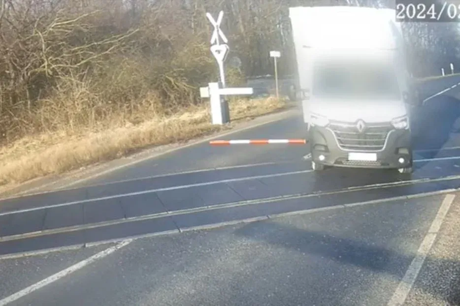 Tökéletes videó: kiütötte a kisbusszal a vasúti sorompót, megállt az átjáró közepén, aztán jött a vonat