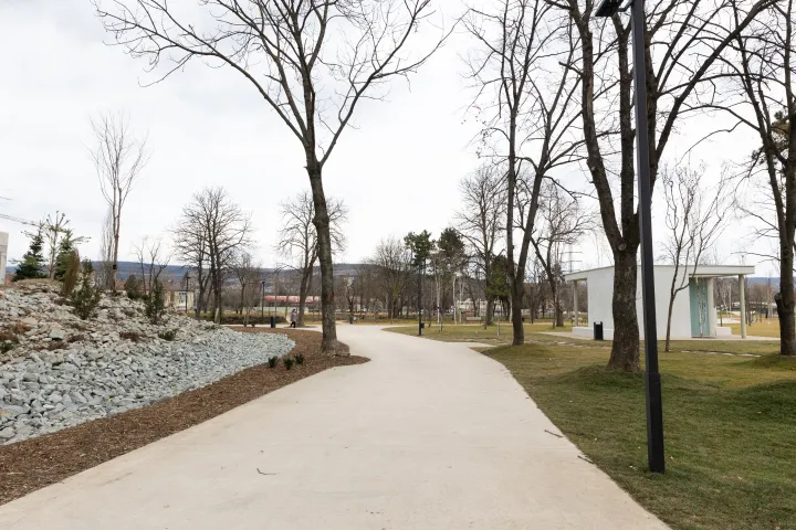 Fent: a Vasutas Park főbejárata, mögötte az épülő tömbházak. Lent: újonnan kialakított ösvény a parkban – Fotó: Tóth Helga / Transtelex