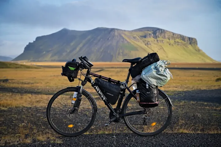 Skógafoss, bike, with Mount Pétursey and the Gjáin Valley in the background – Photography: Martin Ferenc