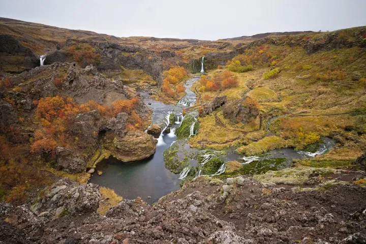 Skógafoss, bike, with Mount Pétursey and the Gjáin Valley in the background – Photography: Martin Ferenc