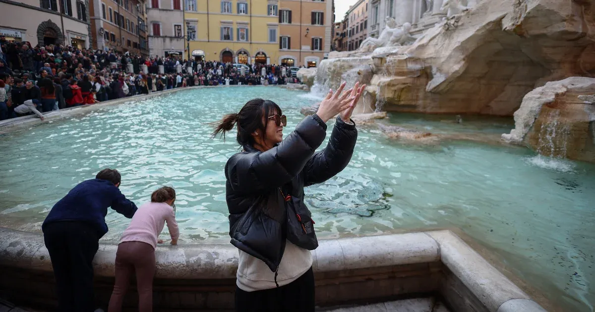 A tönk szélére került embereken segítenek a római Trevi-kutat érmékkel teledobáló turisták