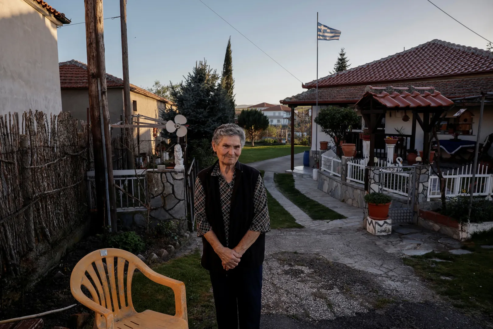 Eléni Triandafilu pózol egy fényképhez a háza előtt a görögországi Orménio faluban – Fotó: Louisa Gouliamaki / Reuters