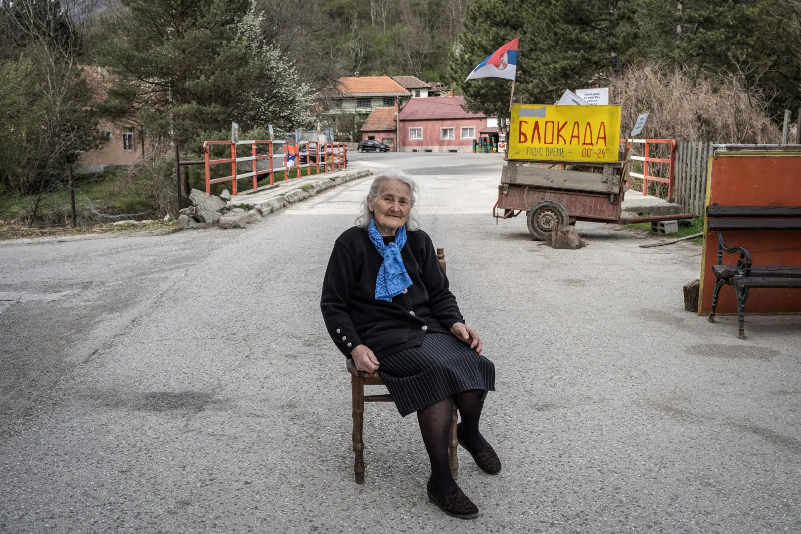 A 78 éves Vukosava Radivojević egy blokád feliratú tábla előtt ül a krivelji útzárnál – Fotó: Marko Djurica / Reuters