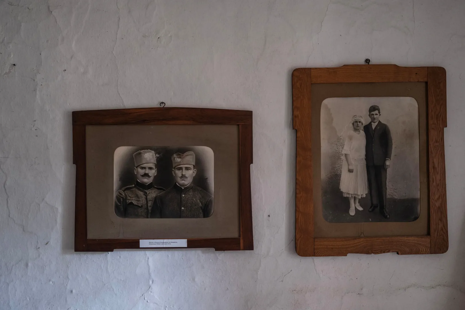Az első világháborúból hazatért katonák és rokonok bekeretezett képei lógnak a Tomić család tulajdonában lévő régi ház falán – Fotó: Marko Djurica / Reuters