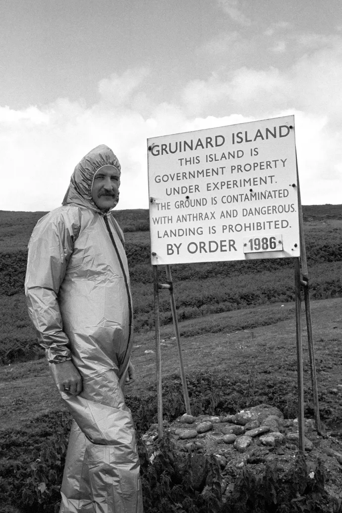 Vegyi és biológiai védelmi létesítmény egyik dolgozója a Gruinard-sziget egyik figyelmeztető táblája mellett 1986-ban a mentesítés idején – Fotó: Pa Images / PA Images