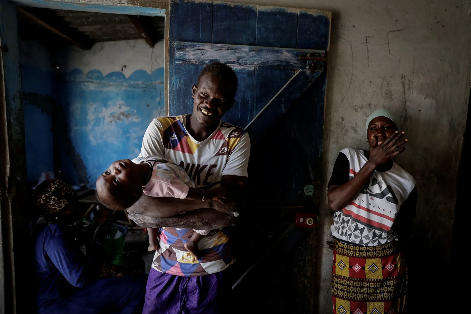 Birane Mbaye karjában tartja egyéves lányát, Maguette-et, mellette felesége, a 21 éves Khady Gueye áll Fass Boye-i otthonukban. – Fotó: Zohra Bensemra / Reuters