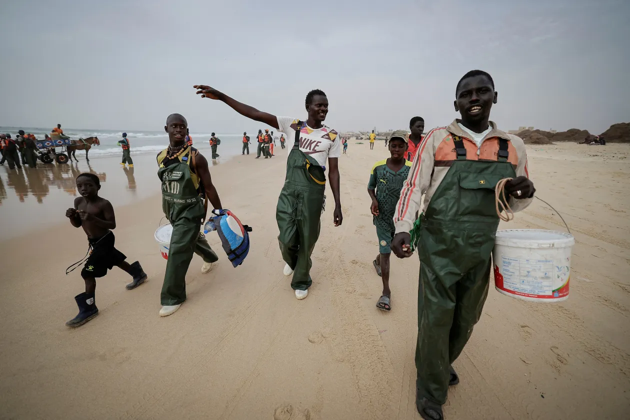 A napi fogással készülnek a piacra (balra), halászok a munka végeztével, köztük Mbaye (jobbra) – Fotó: Zohra Bensemra / Reuters
