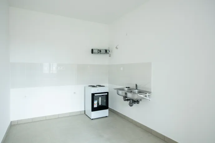 A Gát utca 24. pincéjéből működő hőszivattyús rendszer és az egyik lakás újonnan kialakított konyhája – Fotó: Bődey János / Telex