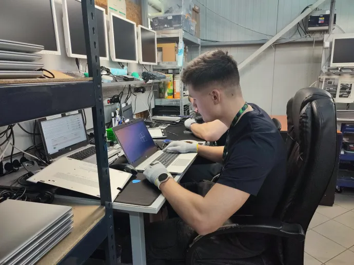 A szervizcsapat dolgozik egy laptopon a Furbifynál – Fotó: Nagy Nikoletta / Telex