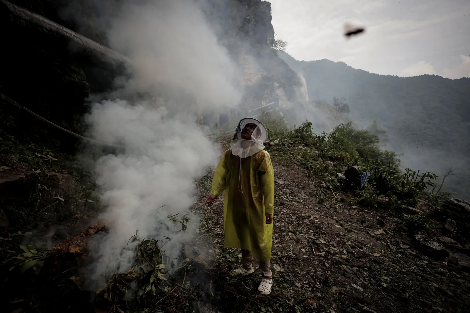 Az egyik falusi tüzet rakott a sziklafal tövében, hogy kifüstölje a fészkükből a méheket – Fotó: Navesh Chitrakar / Reuters