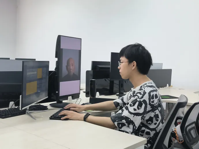 Egy mesterséges intelligenciával foglalkozó technológiai vállalat alkalmazottja bemutatja a digitális „feltámasztás” folyamatát a dél-kínai Nankingban 2024. április 1-jén – Fotó: Guo Yifan / Xinhua News Agency / AFP