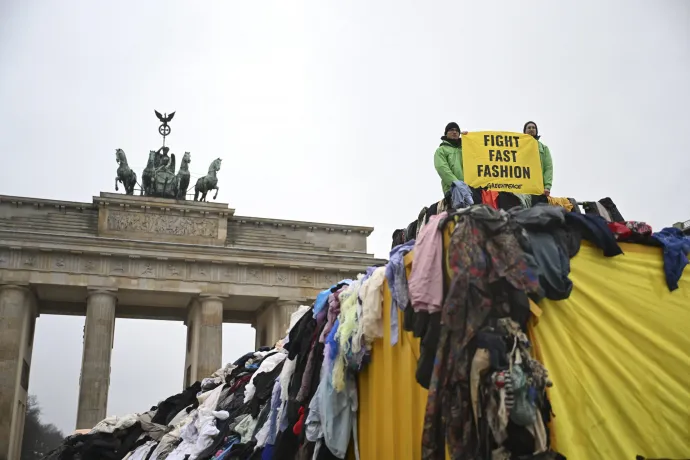 A Greenpeace aktivistái hegynyi textilhulladékkal tiltakoznak a fast fashion környezetkárosító hatásai ellen 2024. február 5-én Berlinben – Fotó: Halil Sagirkaya / Anadolu / Getty Images