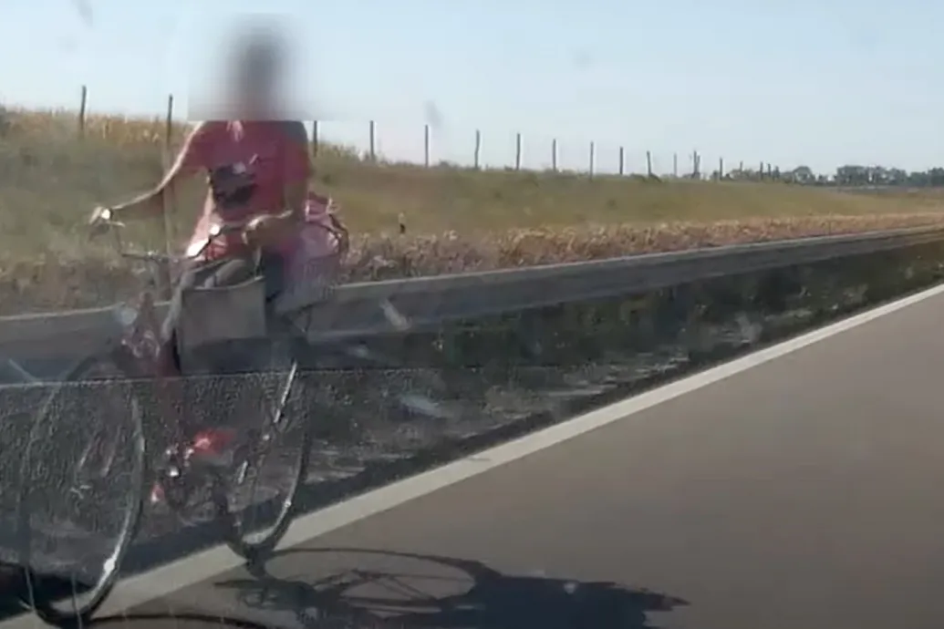 Kosárral a karján, a forgalommal szemben tekert egy biciklis az M5-ösön Kecskemétnél