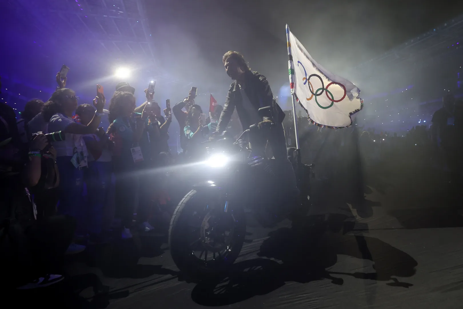 A záróceremónián táncos és zenés előadásokat követően megjelent Tom Cruise, aki a stadion tetejéről leereszkedve átvette Los Angeles polgármesterétől az olimpiai zászlót, és motorra pattanva indult útnak, hogy egy korábban felvett videón elvigye a lobogót Amerikába – Fotó: Jamie Squire / Getty Images