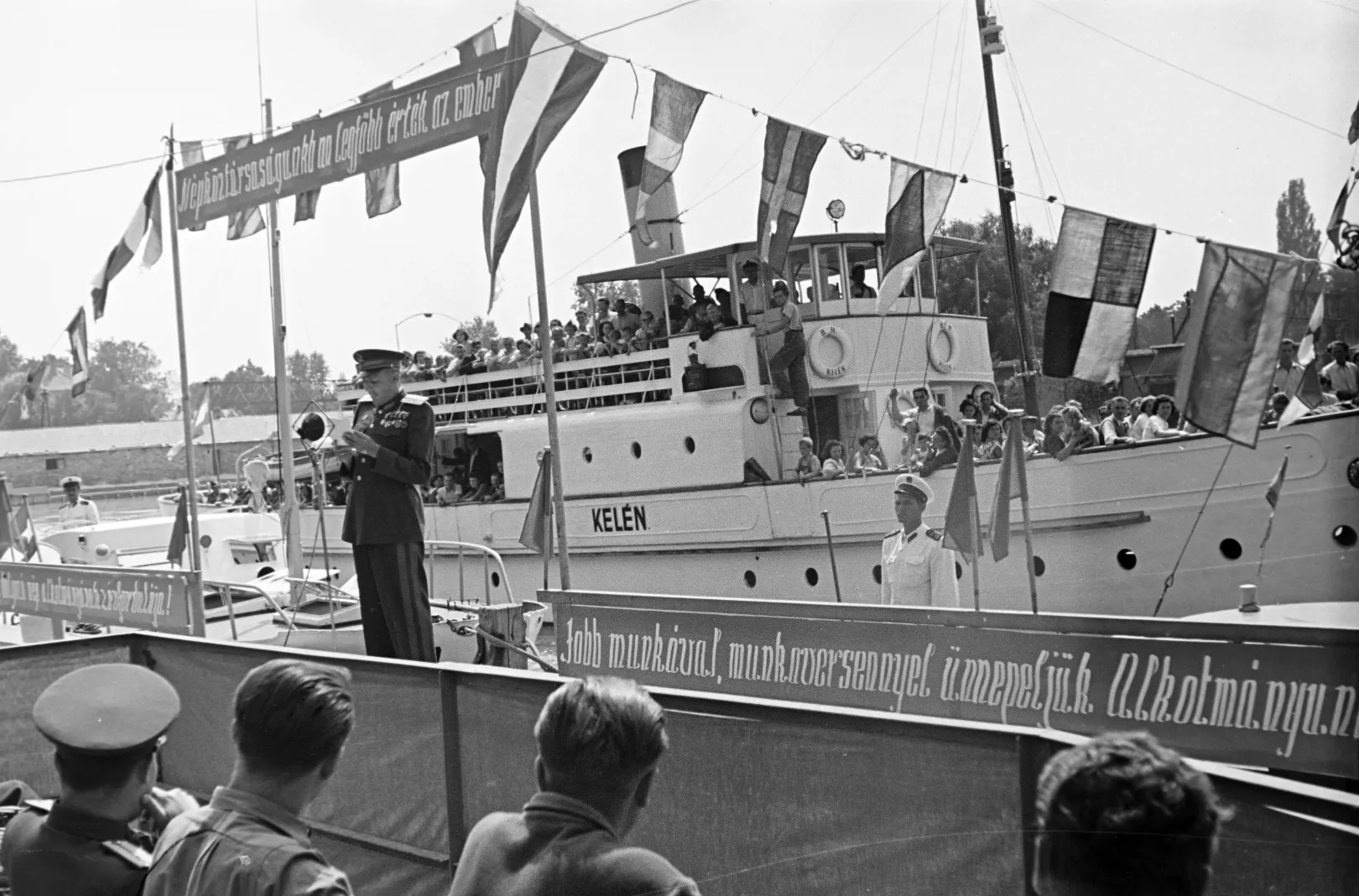 A Móricz Zsigmond, Zalka Máté és a Szamuely Tibor a Balatoni Vízirendészet Siófoki Rendőrörs szolgálati hajóinak ünnepélyes avatása Siófokon 1951-ben, háttérben a Kelén csavargőzös – Fotó: Horváth József / Fortepan