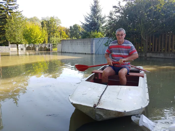 Árvízi helyzet Zebegényben, a második képen Ferenczy Ernő Ervin polgármester mutatja A mappába mentek képek a polgiról, aki kék pólóban áll az ideiglenes gáton és nekem mutatja, hogy a patak vízszintje legalább fél méterrel magasabban van, mint a megóvni kíván ház alapja – Fotó: Zách Dániel / Telex