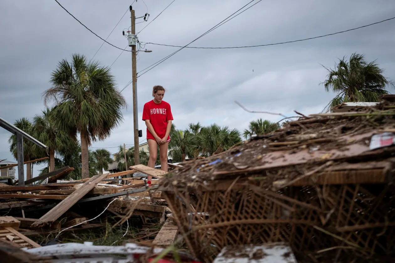 Balra: Piper Wagenman házának romjain áll a floridai Horseshoe Beach-en. Jobbra: Egy sós vízbe hajtott, emiatt felrobbant Tesla áll egy parkolóban a floridai St. Pete Beach-en – Fotó: Marco Bello / Reuters és Ted Richardson / The Washington Post / Getty Images