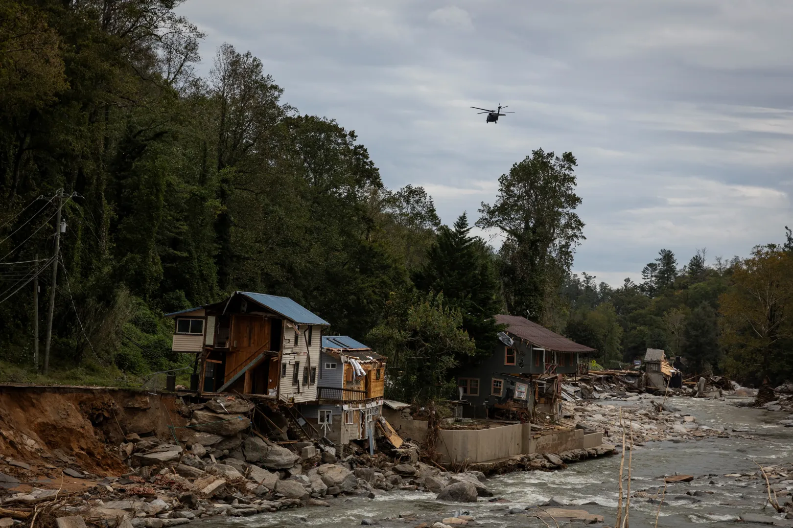 Egy helikopter repül el egy, az áradásokban elpusztított völgy fölött az észak-karolinai Bat Cave-ben 2024. szeptember 30-án – Fotó: Marco Bello / Reuters