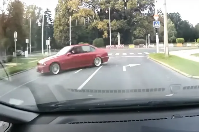 Túltolta a kanyart a piros BMW, beleszállt egy parkoló autóba