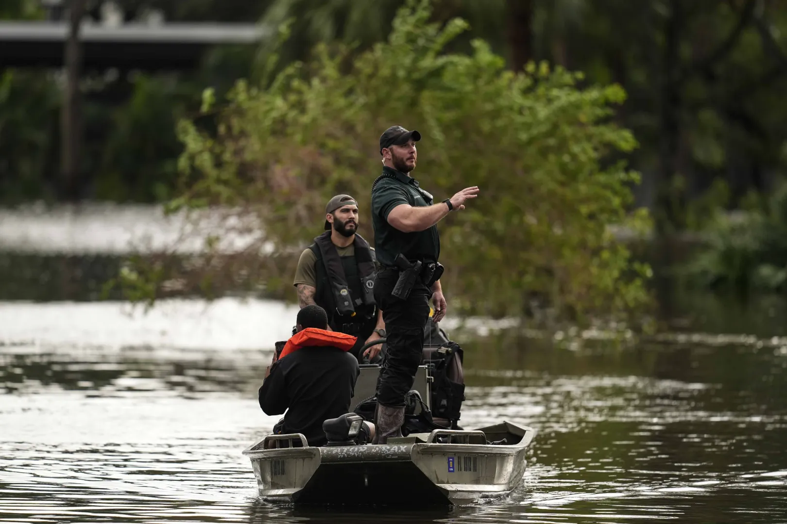 Árvízben sodródó autó mellett halad el a mentőalakulatok csónakja a floridai Clearwaterben 2024. október 10-én, miután a Milton hurrikán átvonult Florida állam középső része fölött, tengeráradást, valamint villámáradásokat és árvizeket okozva. A vihart megelőző napokban több millió embert utasítottak arra, hogy hagyják el otthonukat a várható vihardagály miatt – Fotó: Mike Stewart / AP / MTI