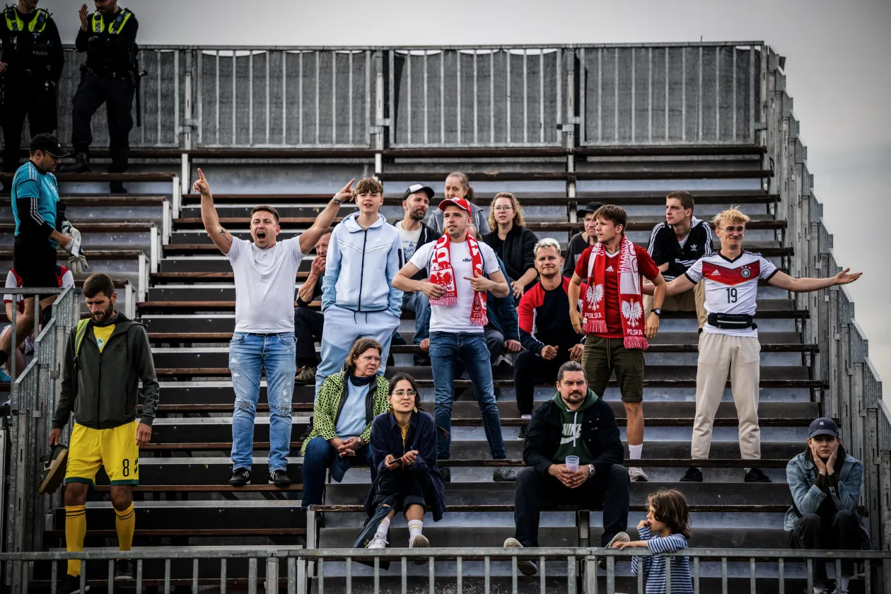 Los miembros del equipo de fútbol húngaro se animan unos a otros antes del partido contra Italia en el campeonato de Hamburgo el 18 de junio, y los aficionados en las gradas animan a sus jugadores favoritos - Fotografía: Marton Munos/Reuters