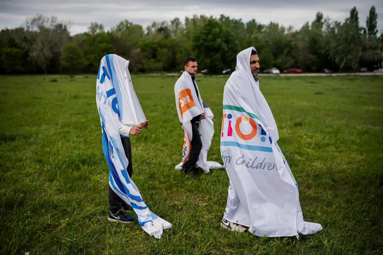 Dos miembros del equipo de fútbol de la Asociación Deportiva Ultalum se abrazan después de un entrenamiento en Budapest, el 2 de mayo de 2021 // Los tres hermanos, David Hamza, de 17 años, Józef Hamza, de 21, y György, de 22 Hamza intenta calentarse durante la sesión de entrenamiento en Budapest, el 2 de mayo de 2021 - Fotografía: Marton Monos/Reuters