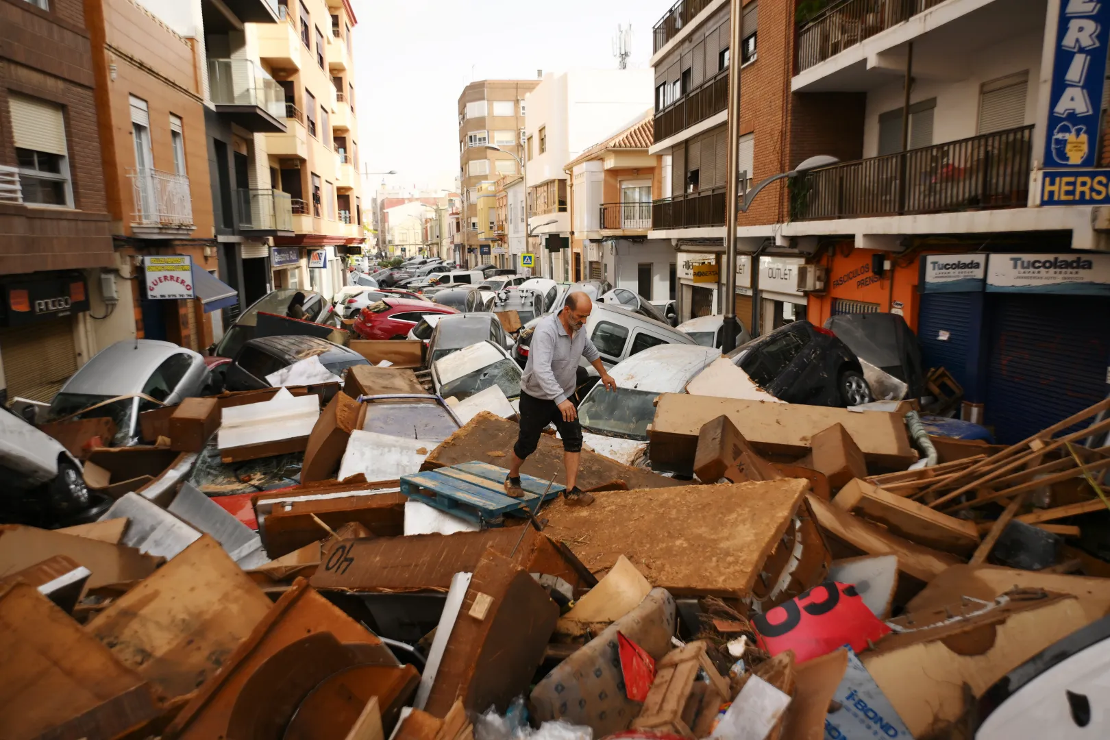 Férfi jár-kel a kidobott bútorok hegyén Valencia tartományban – Fotó: David Ramos / Getty Images