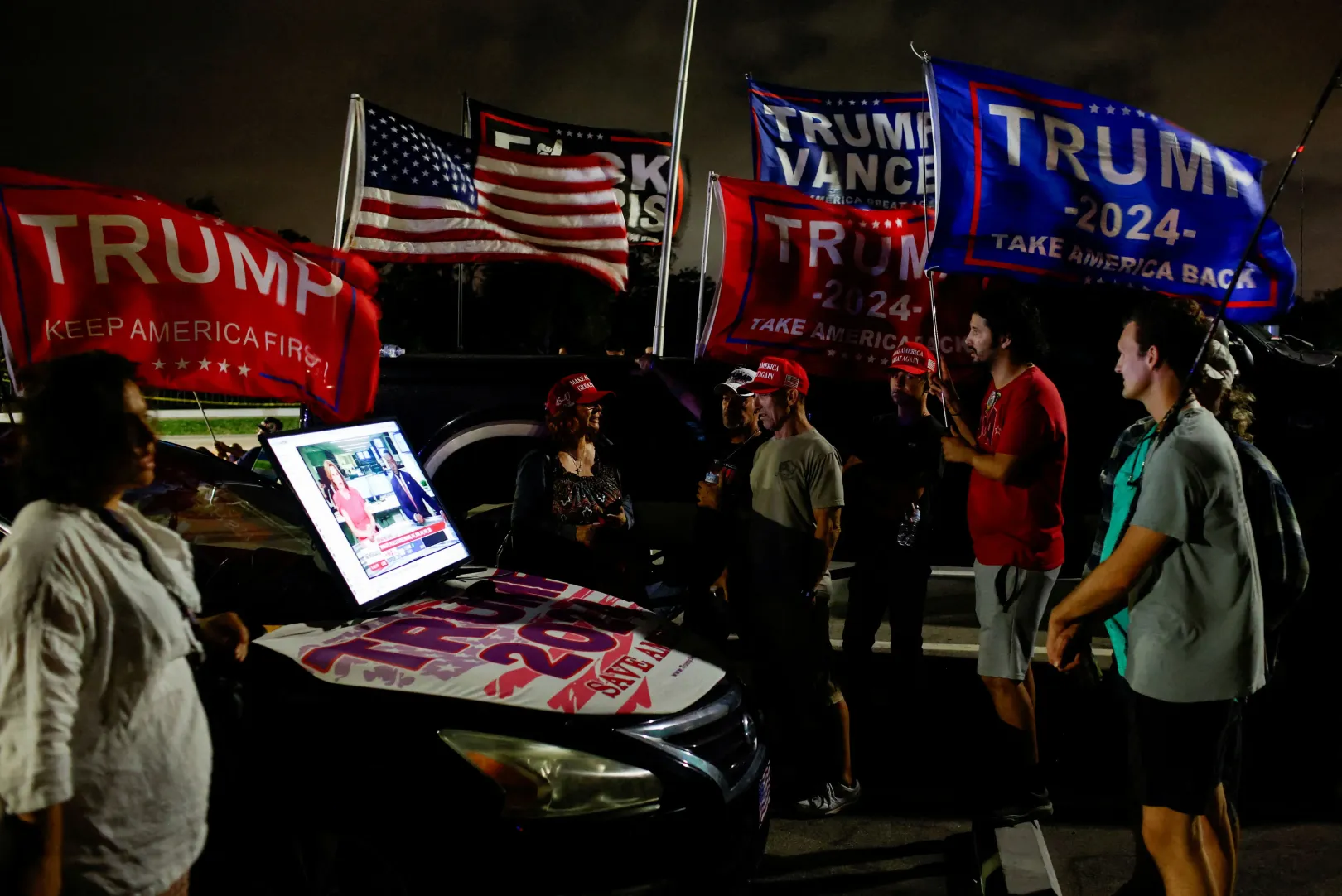 Donald Trump támogatói egy autóhoz csatlakoztatott kivetítőn nézik a választás fejleményeit a floridai Palm Beachen – Fotó: Marco Bello / Reuters