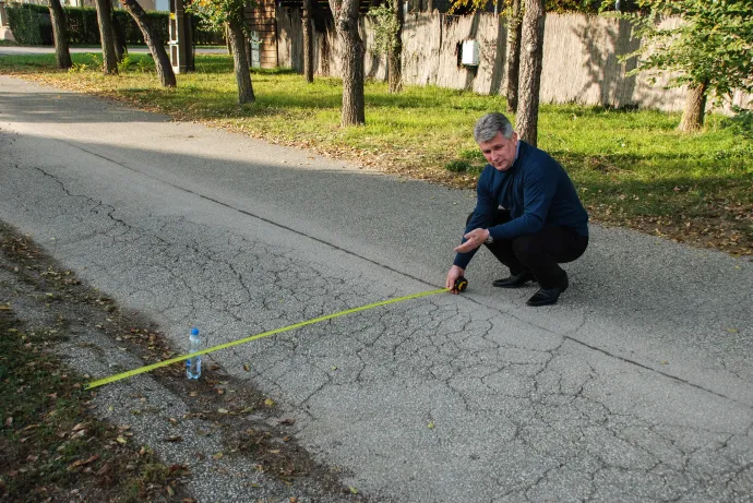 Az útburkolat megsüllyedt, itt nem elég kátyúzni, fel kellene újítani, mutatja Király László, Deszk polgármestere – Fotó: Móra Ferenc Sándor / Telex