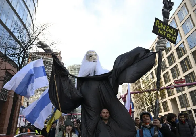 "Putyin itt úgysem jössz át" – feliratú táblával és a Gyűrűk Urából ismert Gandalf figurájával vonul egy tüntető a tüntetésen Berlinben 2024. november 17-én – Fotó: Halil Sagirkaya / 2024 Anadolu / AFP