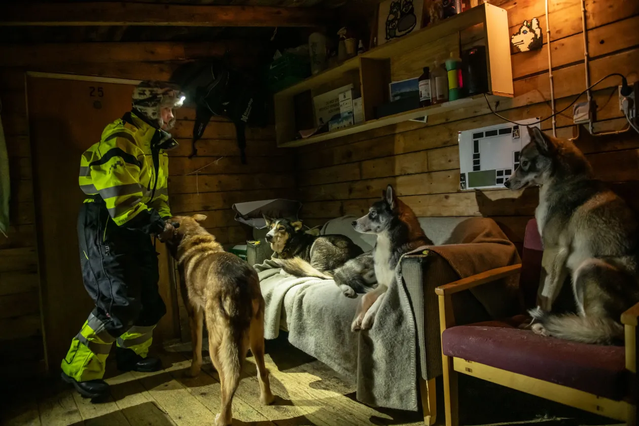 Sunniva Berge Mo, a Kings Bay AS könyvelője egy estét tölt kutyáival a Ny-Ålesund kutyaudvarában. / Yohann Dulong, a francia–német AWIPEV Sarkvidéki Kutatóbázis logisztikai mérnöke (2021–2022) tüzet rak a Gåsebu kabinban, amely néhány kilométerre található Ny-Ålesundtól a Spitzbergákon – Fotó: Esther Horvath