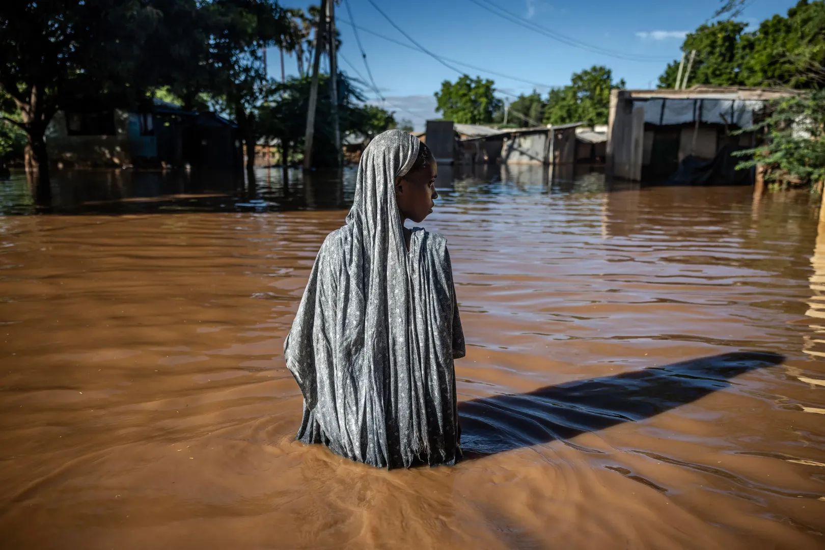 Egy nő lábal át a települését elöntött vízen a kenyai Garissában – Fotó: Luis Tato / AFP