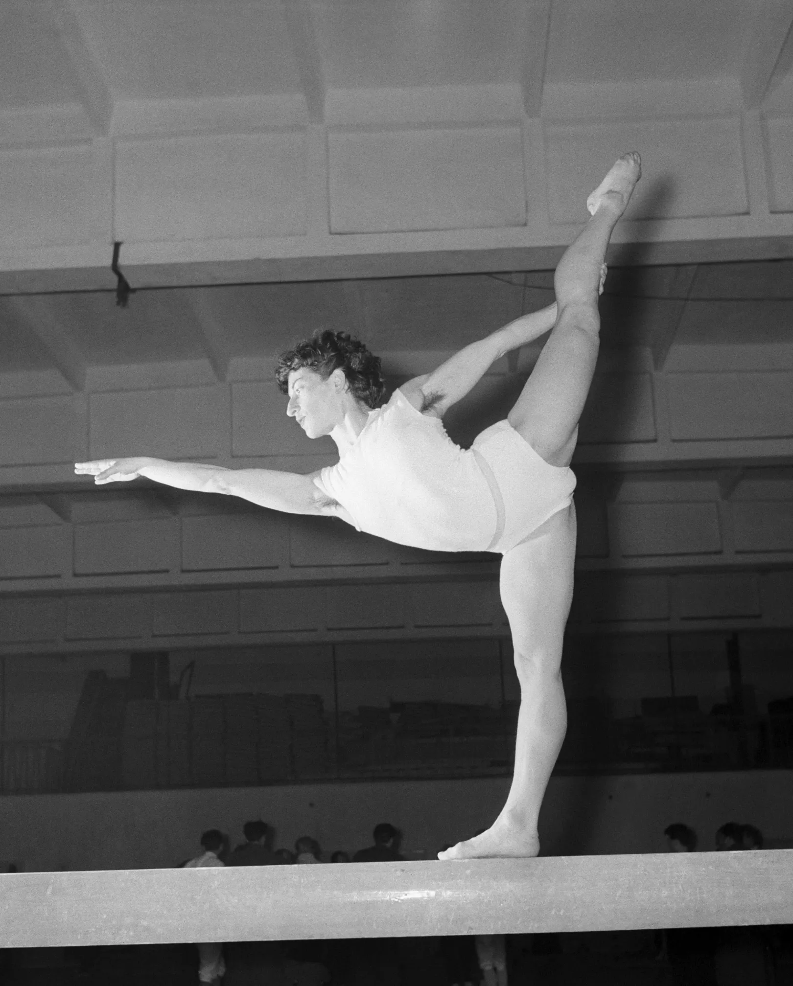 Keleti Ágnes, a XVI. nyári olimpiára készülő magyar tornászválogatott tagja mellső spárgamérleget mutat be a gerendán a tatai edzőtáborban 1956. február 25-én – Fotó: Komlós Tibor / MTI