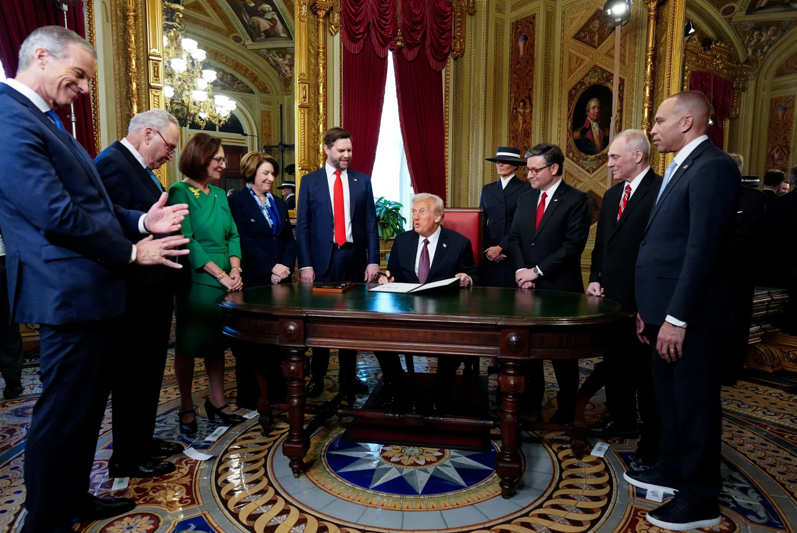 Donald Trump a beiktatás utáni aláírási ceremónián a Capitolium épületében, 2025. január 20-án, a szenátus és a képviselőház demokrata és republikánus vezetőivel, J. D. Vance alelnökkel és Melania Trump first ladyvel – Fotó: Melina Mara / Pool / Reuters