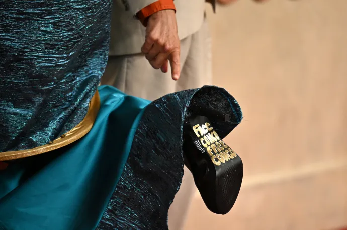 Johan Grimonprez belga filmes Kayo Shekoni színész-énekesnő cipőtalpára mutat a vörös szőnyegen – Fotó: Angela Weiss / AFP