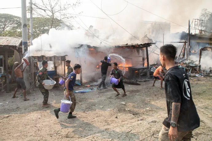 Emberek próbálják eloltani a tüzet a mianmari hadsereg egy korábbi bombázása után a közép-mianmari Mandalaj régióban lévő Szingu településen 2024. március 14-én – Fotó: Str / AFP