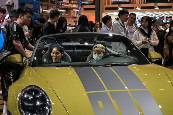 Emberek nézegetnek egy Porsche 911 Spirit 70-et a 21. Sanghaji Nemzetközi Autóipari Kiállításon 2025. április 27-én – Fotó: Hector Retamal / AFP