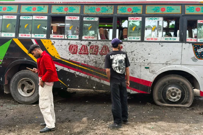 Helyi lakosok állnak egy tűzharcban megrongálódott busz mellett az indiai fennhatóság alatt álló Poonch városában 2025. május 8-án – Fotó: Punit Paranjpe / AFP