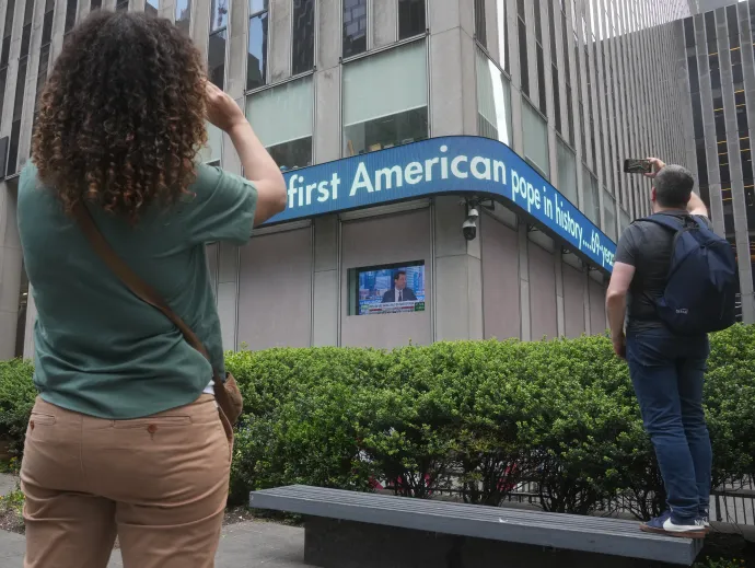 Járókelők a Fox New York-i székházának kijelzőjén követik a pápaválasztást 2025. május 8-án – Fotó: Timothy A. Clary / Reuters